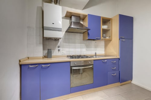 Modern kitchen in Ground floor apartment at Sleep tight Florence B&B, Firenze, with blue cabinetry, wood counters, gas
