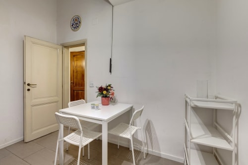 Ground floor apartment at Sleep tight Florence with white dining table, chairs, floral arrangement, and cream doors in