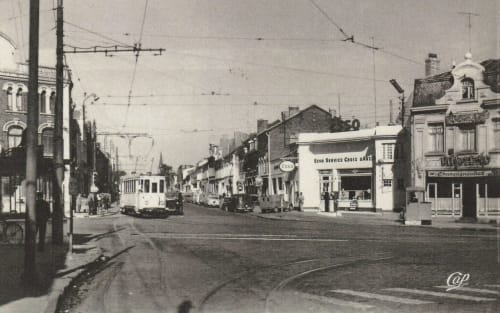 Scène de rue historique à Valenciennes avec un tramway vintage et des façades commerciales de l'époque du Grand Duc