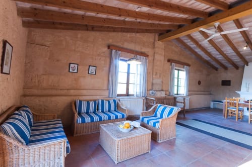 Sa Casa Rotja | Sineu, España -Este apartamento es el más grande, ideal para grupos de amigos, una gran família o dos famílias. Tiene una gran sala comedor con chimenea en la planta de abajo. Con una gran mesa para 8 personas o más. Además dispone de sofás y butacas para descansar. En la planta superior está la cocina con todo lo necesario para cocinar y comer, la terraza privada con vistas al patio, el baño completo y las tres habitaciones. En cada habitación hay dos camas individuales.