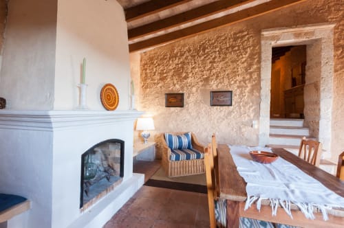 Sa Casa Rotja | Sineu, España -Este apartamento es el más grande, ideal para grupos de amigos, una gran família o dos famílias. Tiene una gran sala comedor con chimenea en la planta de abajo. Con una gran mesa para 8 personas o más. Además dispone de sofás y butacas para descansar. En la planta superior está la cocina con todo lo necesario para cocinar y comer, la terraza privada con vistas al patio, el baño completo y las tres habitaciones. En cada habitación hay dos camas individuales.