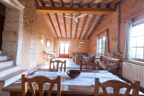 Sa Casa Rotja | Sineu, España -Este apartamento es el más grande, ideal para grupos de amigos, una gran família o dos famílias. Tiene una gran sala comedor con chimenea en la planta de abajo. Con una gran mesa para 8 personas o más. Además dispone de sofás y butacas para descansar. En la planta superior está la cocina con todo lo necesario para cocinar y comer, la terraza privada con vistas al patio, el baño completo y las tres habitaciones. En cada habitación hay dos camas individuales.