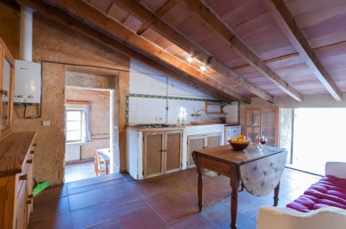 Sa Casa Rotja | Sineu, España -Este apartamento es el más grande, ideal para grupos de amigos, una gran família o dos famílias. Tiene una gran sala comedor con chimenea en la planta de abajo. Con una gran mesa para 8 personas o más. Además dispone de sofás y butacas para descansar. En la planta superior está la cocina con todo lo necesario para cocinar y comer, la terraza privada con vistas al patio, el baño completo y las tres habitaciones. En cada habitación hay dos camas individuales.