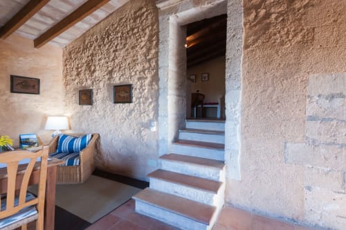 Sa Casa Rotja | Sineu, España -Este apartamento es el más grande, ideal para grupos de amigos, una gran família o dos famílias. Tiene una gran sala comedor con chimenea en la planta de abajo. Con una gran mesa para 8 personas o más. Además dispone de sofás y butacas para descansar. En la planta superior está la cocina con todo lo necesario para cocinar y comer, la terraza privada con vistas al patio, el baño completo y las tres habitaciones. En cada habitación hay dos camas individuales.