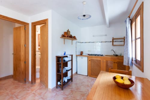 Sa Casa Rotja | Sineu, España -Este apartamento se caracteriza por tener un bonito porche. En la terraza hay mobiliario para su relax y para que disfrute del entorno que le rodea. El apartamento tiene cocina/sala de estar con todo lo necesario para cocinar y comer. En la sala de estar hay un sofá cama por si hay huéspedes extra. En la habitación hay una cama de matrimonio y cuenta con un baño completo. Este apartamento no tiene ningún escalón y es de fa´cil acceso.