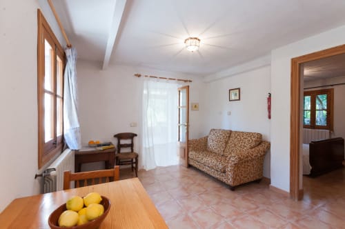 Sa Casa Rotja | Sineu, España -Este apartamento se caracteriza por tener un bonito porche. En la terraza hay mobiliario para su relax y para que disfrute del entorno que le rodea. El apartamento tiene cocina/sala de estar con todo lo necesario para cocinar y comer. En la sala de estar hay un sofá cama por si hay huéspedes extra. En la habitación hay una cama de matrimonio y cuenta con un baño completo. Este apartamento no tiene ningún escalón y es de fa´cil acceso.