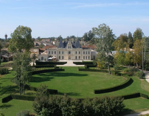 Élégant château avec tourelles entouré de jardins entretenus et d'arbres à Lussac, France