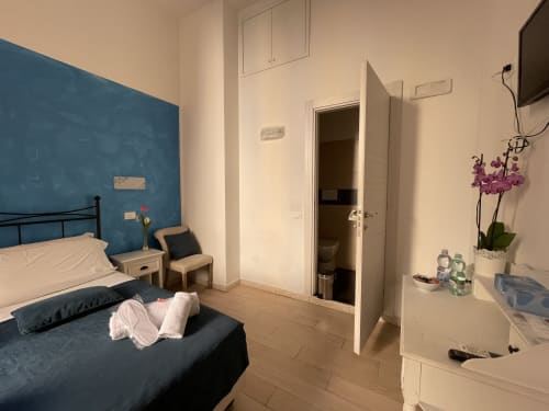 Camera luminosa presso AD Trastevere Guest House Roma con parete azzurra, letto e bagno ensuite