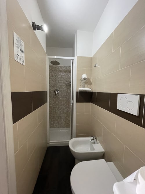 Bagno moderno dell'AD Trastevere Guest House Roma con piastrelle beige e scure, doccia, wc e bidet