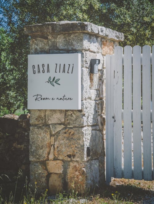Insegna d'ingresso di Casa Ziazì Room e Nature su cancello in pietra con recinzione bianca, Monopoli, Italia