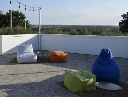 Terrazza panoramica di Casa Ziazì con colorati pouf, luci decorative e vista sulla campagna di Monopoli