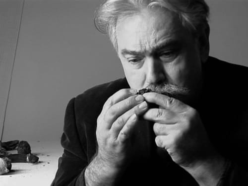 Older man with grey hair and mustache enjoying a cigar at Le Grand Duc, Valenciennes