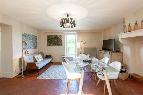 Spacious living room at Les Maisons de Chamirey in Mercurey with dining table, sofa, TV, and garden views