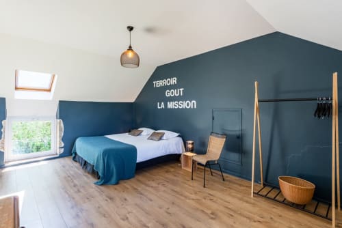 Modern bedroom at Les Maisons de Chamirey in Mercurey with blue accent wall, bed, and garden views