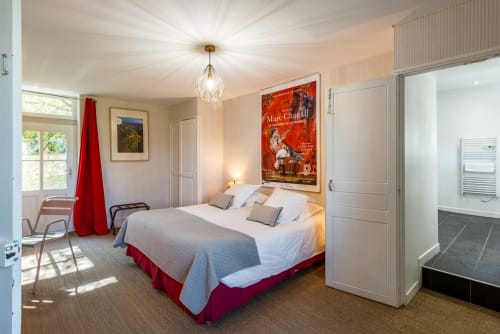 Bright bedroom at Les Maisons de Chamirey in Mercurey with queen bed, red accents, garden views, and modern amenities