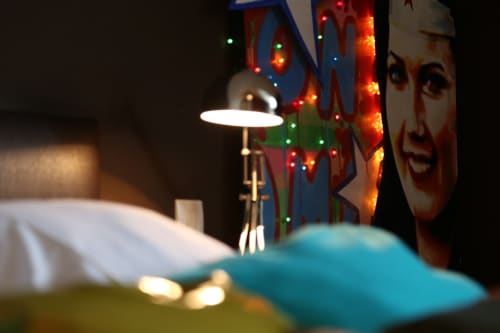 Cozy nighttime workspace at Le Grand Duc, Valenciennes with desk lamp and neon signage