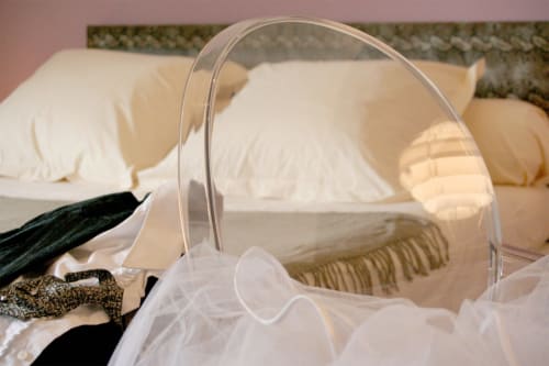 Lit luxueux aux draps blancs et moustiquaire à l'hôtel boutique Le Grand Duc à Valenciennes