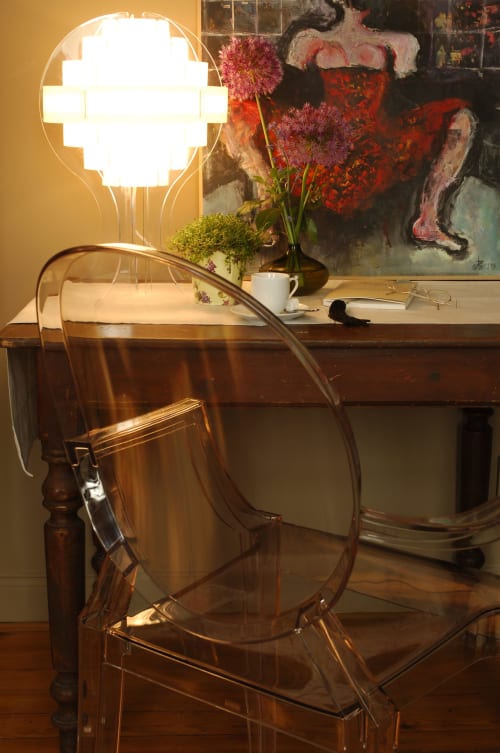 Bureau moderne au B&B Le Grand Duc à Valenciennes avec chaise transparente, lampe lumineuse et composition florale