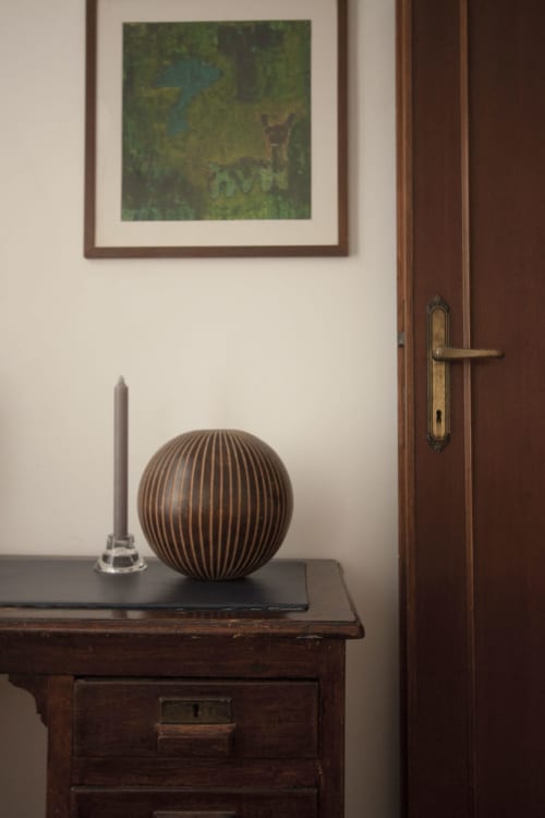 Wooden desk with striped bronze sphere and candle in Ca Cortigiane Venice apartment