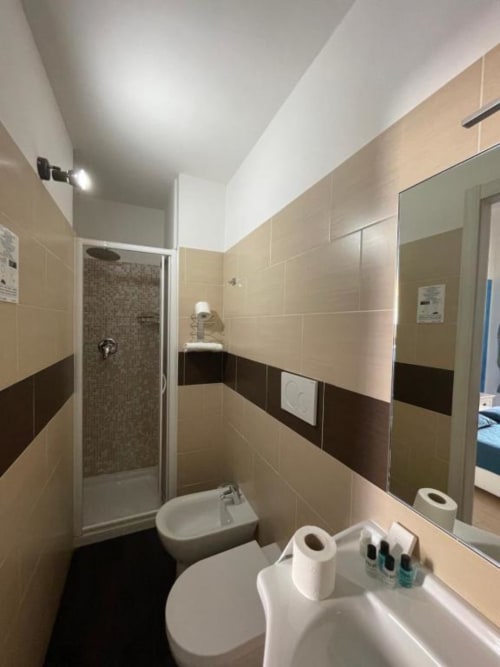 Modern bathroom at AD Trastevere Guest House Rome with beige and brown tiles, shower enclosure, and white fixtures
