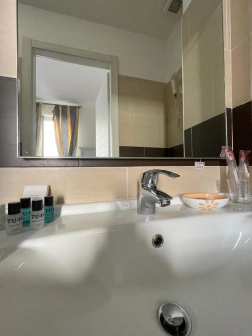 Modern bathroom sink and mirror at AD Trastevere Guest House, Roma with white countertop and amenities