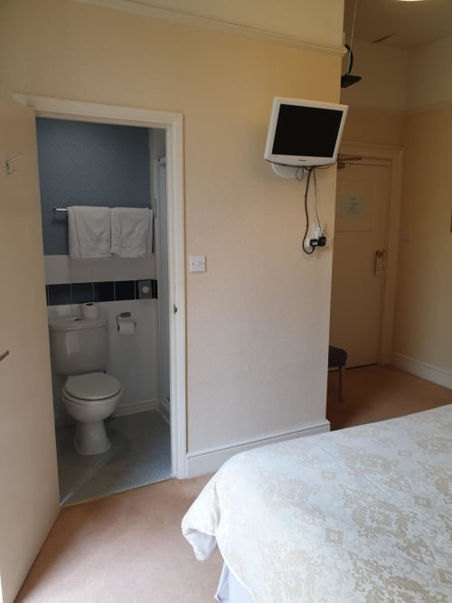 Hotel room at The Sands Hotel in Paignton with bed, en-suite bathroom, and wall-mounted TV
