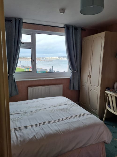 Sands Hotel bedroom with sea view of Paignton beach, bed, wardrobe and window overlooking bay