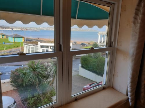 The Sands Hotel in Paignton offers bay views from windows overlooking the beach, sea, and coastal town landscape.