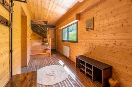 Entrée spacieuse du chalet, avec rangement pour chaussures et porte manteaux. 