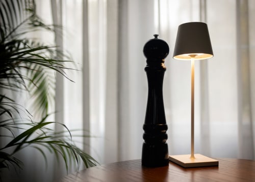Elegant table lamp and black pepper grinder at Le Petit Château, a French bed and breakfast in Baye