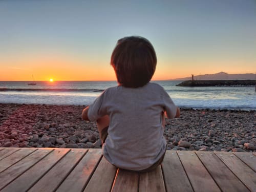 Child watching sunset near Casita on the beach
