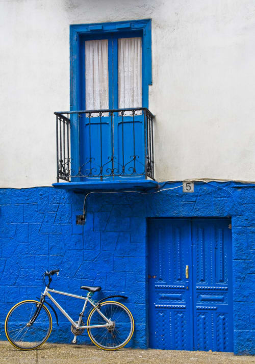 Fachada tradicional vasca azul brillante con puerta balconera, entrada de madera y bicicleta en Casa rural MAÑARINEGI en Gipuzkoa