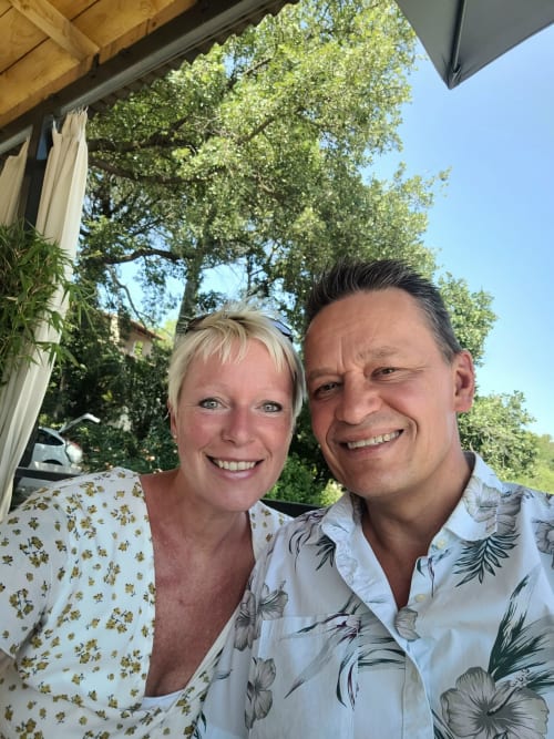 Deux clients souriants apprécient la terrasse ensoleillée de la Villa Thébaïde, gîte à Laudun-l'Ardoise en France
