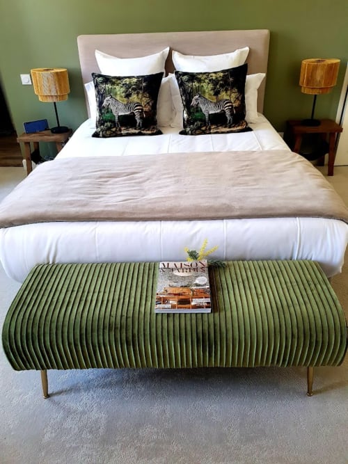 Chambre élégante au Pavillon Des Millésimes aux murs vert sauge, lit capitonné, coussins zébrés et banquette assortie