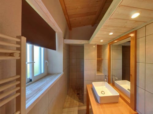 Salle de bains moderne de la villa Le Maquis Plage avec double vasque, plafond en bois et lumière naturelle