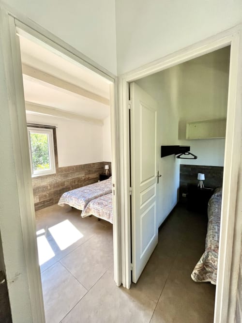 Couloir de la villa Le Maquis Plage avec deux chambres communicantes équipées de salles de bain privées, Poggio-Mezzana