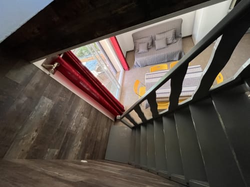 Chambre à l'étage de la villa Le Maquis Plage à Poggio-Mezzana avec lit, accents jaunes et fenêtres avec vue sur mer