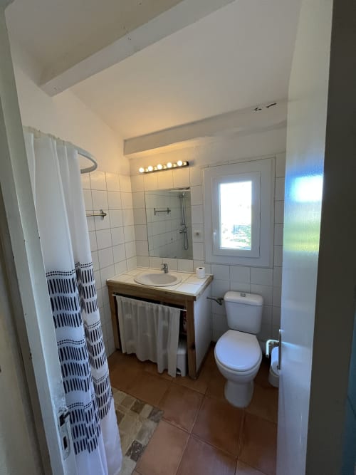 Salle de bain moderne de la villa Le Maquis Plage à Poggio-Mezzana avec douche, toilettes, lavabo et miroir éclairé