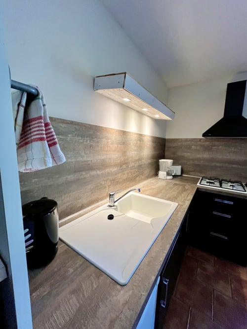 Évier et plan de travail modernes avec dosseret en bois à la villa Le Maquis Plage, Poggio-Mezzana