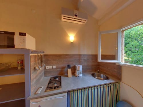 Cuisine aménagée de la villa Le Maquis Plage à Poggio-Mezzana avec cuisinière, évier et équipements modernes