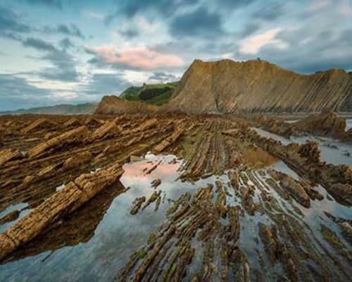 Acantilados de basalto columnar y piscinas de marea en la costa de Gipuzkoa, País Vasco, España, cerca de Casa rural MAÑARINEGI