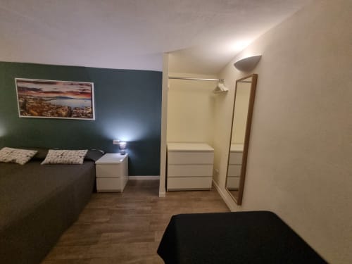 Superior Suite bedroom at B&B Il Conservatorio in Naples, featuring green accent wall, bed, white nightstand, and ensuite