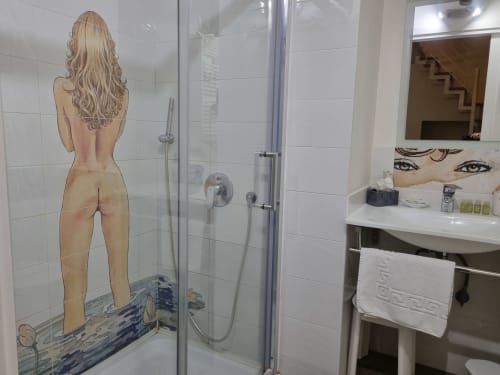 Modern bathroom in Superior Suite at B&B Il Conservatorio Naples with glass shower, sink, mirror, and decorative artwork on