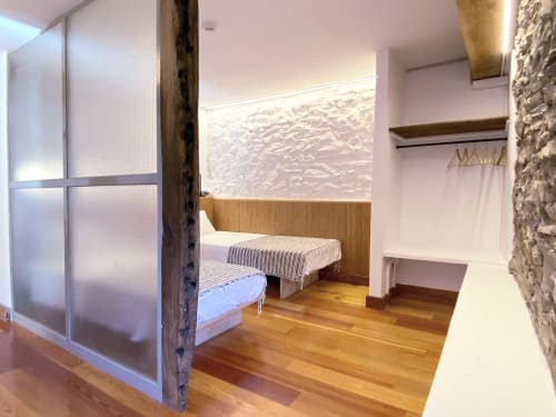 Moderno dormitorio en Casa rural MAÑARINEGI con dos camas, suelo de madera y mobiliario contemporáneo en Gipuzkoa