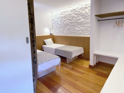 Dormitorio doble en apartamento Casa rural MAÑARINEGI con suelos de madera, ropa de cama blanca y arte mural texturizado en Gipuzkoa