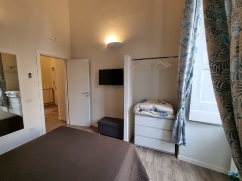 Spacious luxury family suite at B&B Il Conservatorio Naples with double bed, TV, balcony access, and modern furnishings