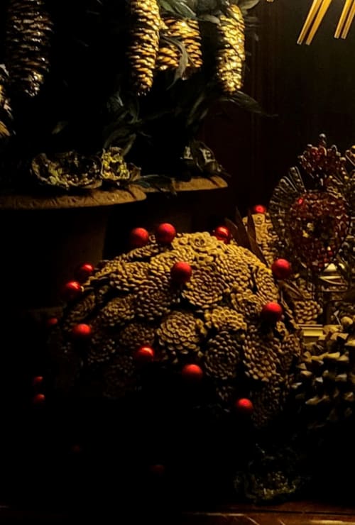 Décoration festive de Noël avec pommes de pin dorées et baies rouges au Grand Duc, Valenciennes