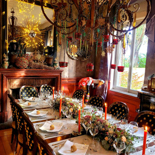 Élégante salle à manger du B&B Le Grand Duc à Valenciennes avec décoration festive, miroir en soleil doré et table aux thèmes des fêtes