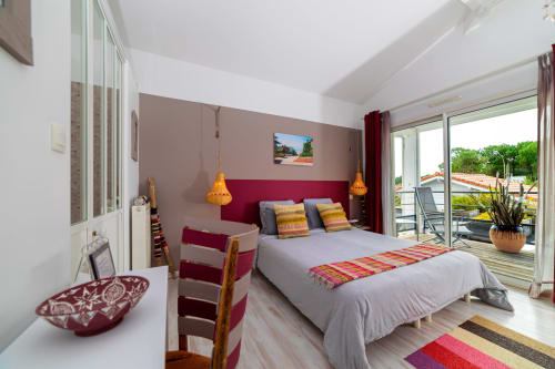 Chambre moderne à Cote Et Dune aux accents bordeaux, luminaires dorés et terrasse vue sur Biscarrosse Plage