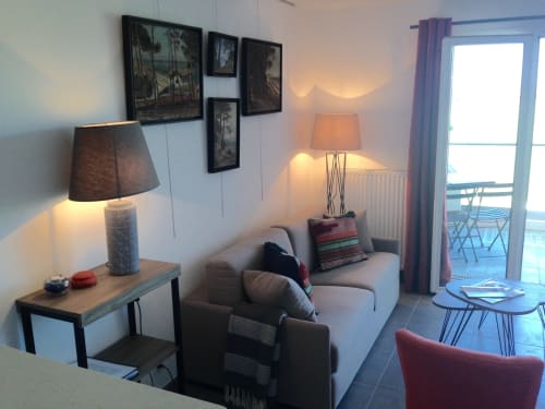 Cozy living room at Cote Et Dune hotel in Biscarrosse Plage with comfortable seating, lamps, and ocean view balcony access.